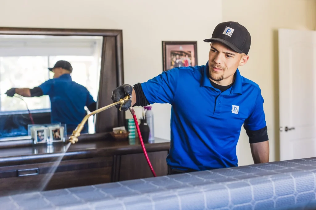 bed bug exterminator spraying pro treat plus chemical treatment in an Arizona home